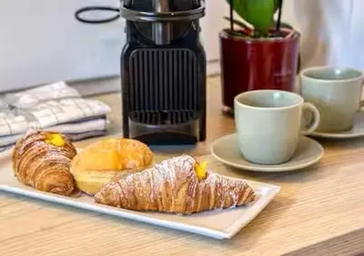 a table with a plate of pastries and a cup of coffee at Vittoriano Pantheon apartment in Rome