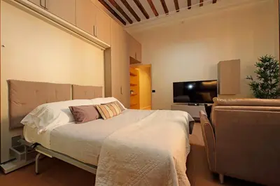 a bedroom with a bed and a couch and a television at Loft al Pantheon by Luxury Getaways in Rome