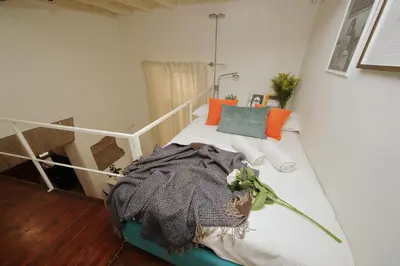 a small bedroom with a bed with a white rail at Quiet nest in Campo De' Fiori in Rome