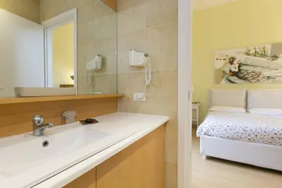 a bathroom with a sink and a toilet and a mirror at Rome Central Suite via Porcari in Rome