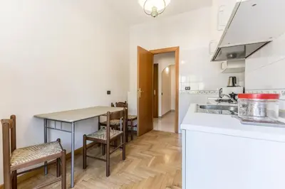a kitchen with white counters and a table and chairs at Guest House Ionio in Rome