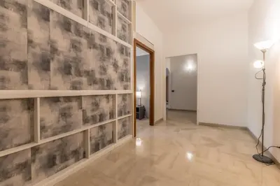 a hallway with a large wall with wooden shelves at Guest House Ionio in Rome