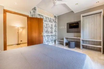 a bedroom with a bed and a tv on a wall at Guest House Ionio in Rome