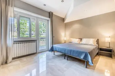 a bedroom with a bed and two windows at Guest House Ionio in Rome