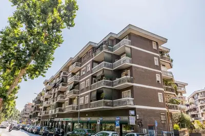 a tall building with cars parked in front of it at Guest House Ionio in Rome