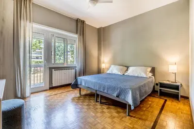 a bedroom with a bed and two windows at Guest House Ionio in Rome