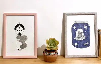 two picture frames sitting on a table with a plant at Casa di Ross in Rome