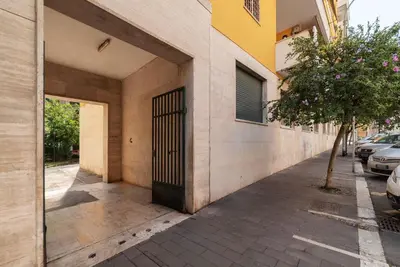 a building with a gate on the side of a street at GuestHost - Colorful Apt in Vintage-Modern Style in Rome