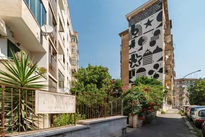 a street with a sign on the side of a building at GuestHost - Colorful Apt in Vintage-Modern Style in Rome