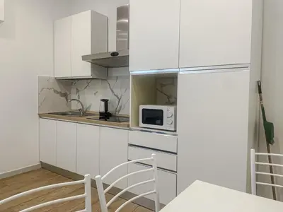 a kitchen with white cabinets and a microwave at Family Domus Via Latina in Rome