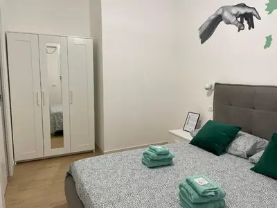 a bedroom with a bed with green towels on it at Family Domus Via Latina in Rome
