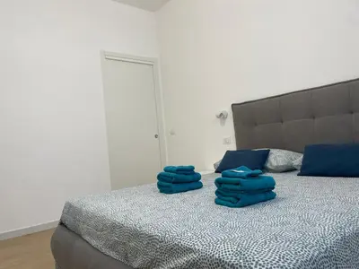 a bed with blue pillows on top of it at Family Domus Via Latina in Rome