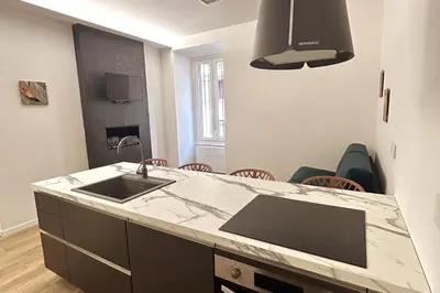 a kitchen with a sink and a counter with chairs at Roma city center stay San Giovanni in Rome