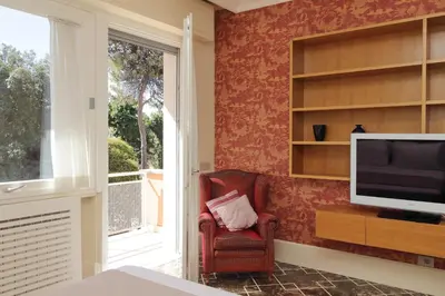 a living room with a chair and a television at YCH-Elegante appartamento vicino Villa Ada in Rome