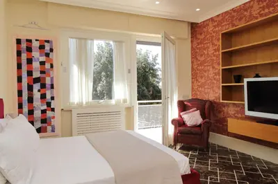 a bedroom with a bed and a tv and a chair at YCH-Elegante appartamento vicino Villa Ada in Rome