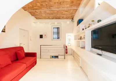 a living room with a red couch and a flat screen tv at Roma Suite Piazza Navona in Rome