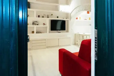 a living room with a red couch and a tv at Roma Suite Piazza Navona in Rome