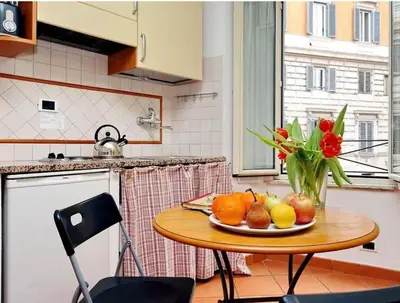 a table with a plate of fruit and a vase of flowers at 600mt To Colosseum in Rome
