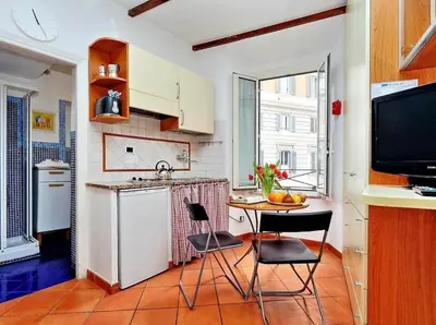 a kitchen with a table and chairs and a tv at 600mt To Colosseum in Rome
