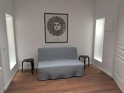 a room with a gray ottoman and two stools at Pigneto New collection 1 in Rome