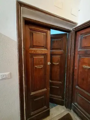 an open door into a room with wooden doors at Pigneto New collection 1 in Rome