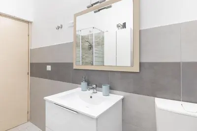 a bathroom with a white sink and a mirror at Rome Capital Apartments in Rome