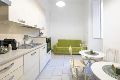 a kitchen with a table and a green couch at Rome Capital Apartments in Rome