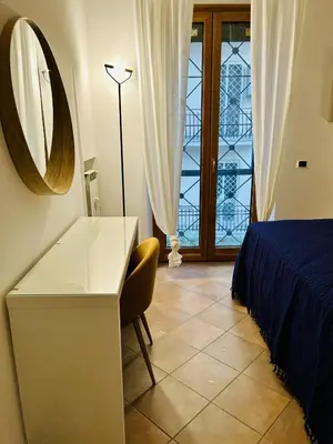 a bedroom with a desk and a bed and a mirror at casa di Stefano in Vaticano in Rome