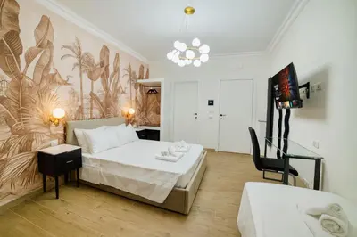 a bedroom with a bed and a table and a chair at Radio Suites in Rome
