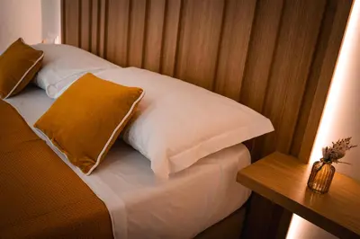 a bed with two pillows and a side table at Alma Guest House in Rome