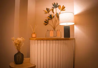a table with a lamp and a vase with flowers at Alma Guest House in Rome