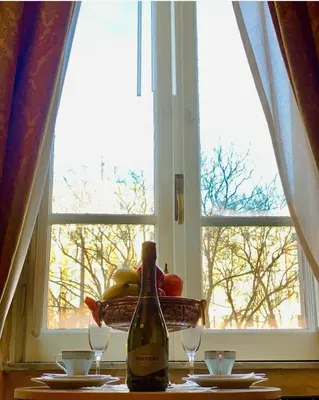 a bottle of wine sitting on a table in front of a window at Pope's Suites in Rome