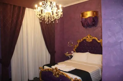 a bedroom with a bed and a chandelier at Pope's Suites in Rome