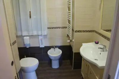 a small bathroom with a toilet and a sink at Pope's Suites in Rome
