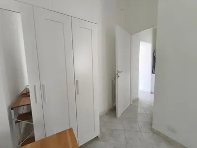 a white room with white cabinets and a hallway at the italians house in Roma San Lorenzo in Rome
