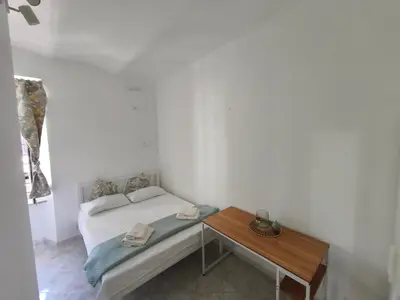 a small bedroom with a bed and a table at the italians house in Roma San Lorenzo in Rome