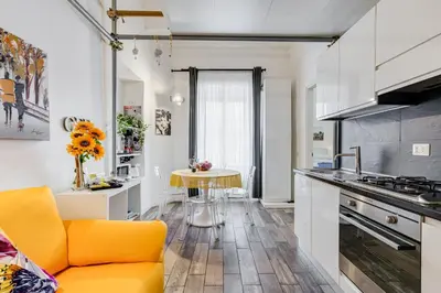 a kitchen with a yellow couch and a table at Apartment near the Vatican in Rome