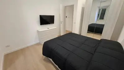 a bedroom with a black bed and a flat screen tv at Pigneto New collection 2 Casilina in Rome