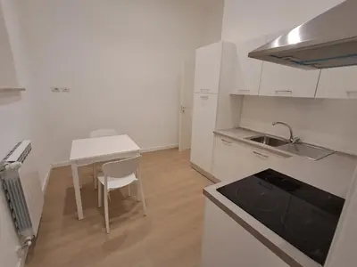 a white kitchen with a table and a sink at Pigneto New collection 3 Perugia in Rome