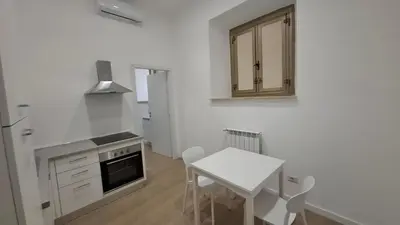 a kitchen with a table and a stove and a table and chairs at Pigneto New collection 3 Perugia in Rome