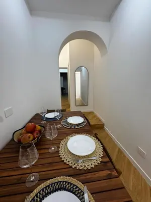 a dining room table with plates and wine glasses on it at The Roman Retreat - 2BDR Colosseum Monti district in Rome