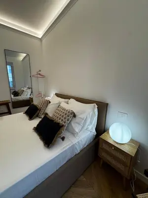 a bedroom with a bed with pillows and a mirror at The Roman Retreat - 2BDR Colosseum Monti district in Rome