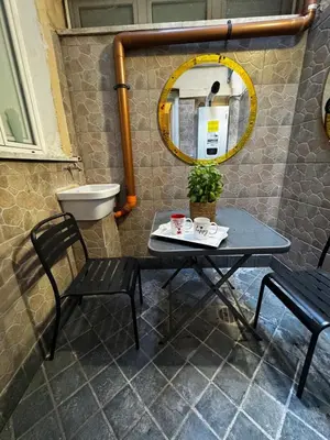 a table and two chairs and a mirror in a bathroom at The Roman Retreat - 2BDR Colosseum Monti district in Rome