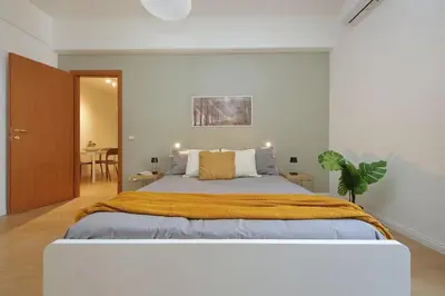 a bedroom with a large bed and a table at Circo Massimo House by Luxury Getaways in Rome