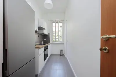 a white kitchen with a sink and a stove at Circo Massimo House by Luxury Getaways in Rome
