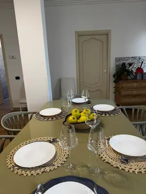 a table with plates and glasses and a bowl of fruit at Roman Holiday Escape 2BDR Spanish steps and Trevi in Rome