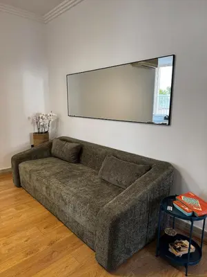 a couch in a living room with a large mirror at Roman Holiday Escape 2BDR Spanish steps and Trevi in Rome