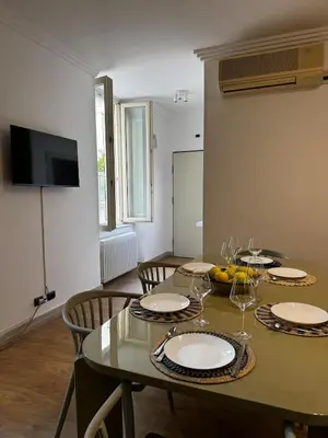 a dining room table with plates and wine glasses on it at Roman Holiday Escape 2BDR Spanish steps and Trevi in Rome