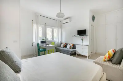 a white living room with a bed and a desk at Aurelia vetus apartment Rome in Rome