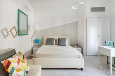a white bedroom with a bed and a couch at Aurelia vetus apartment Rome in Rome